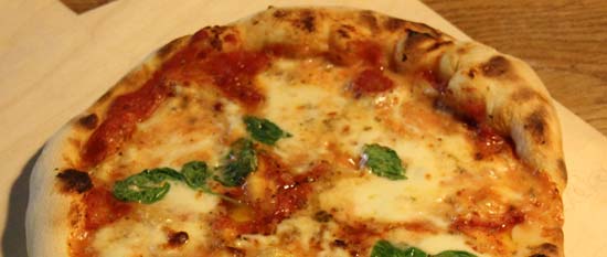 Pizza Margherita mit Mozzarella, Olivenöl und Basilikum